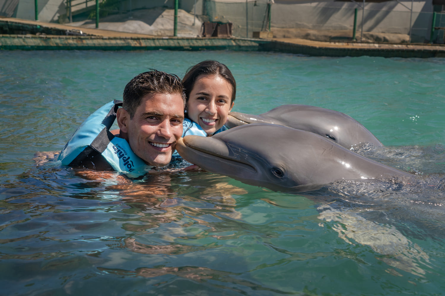 couple swimming with dolphins in Isla Mujeres