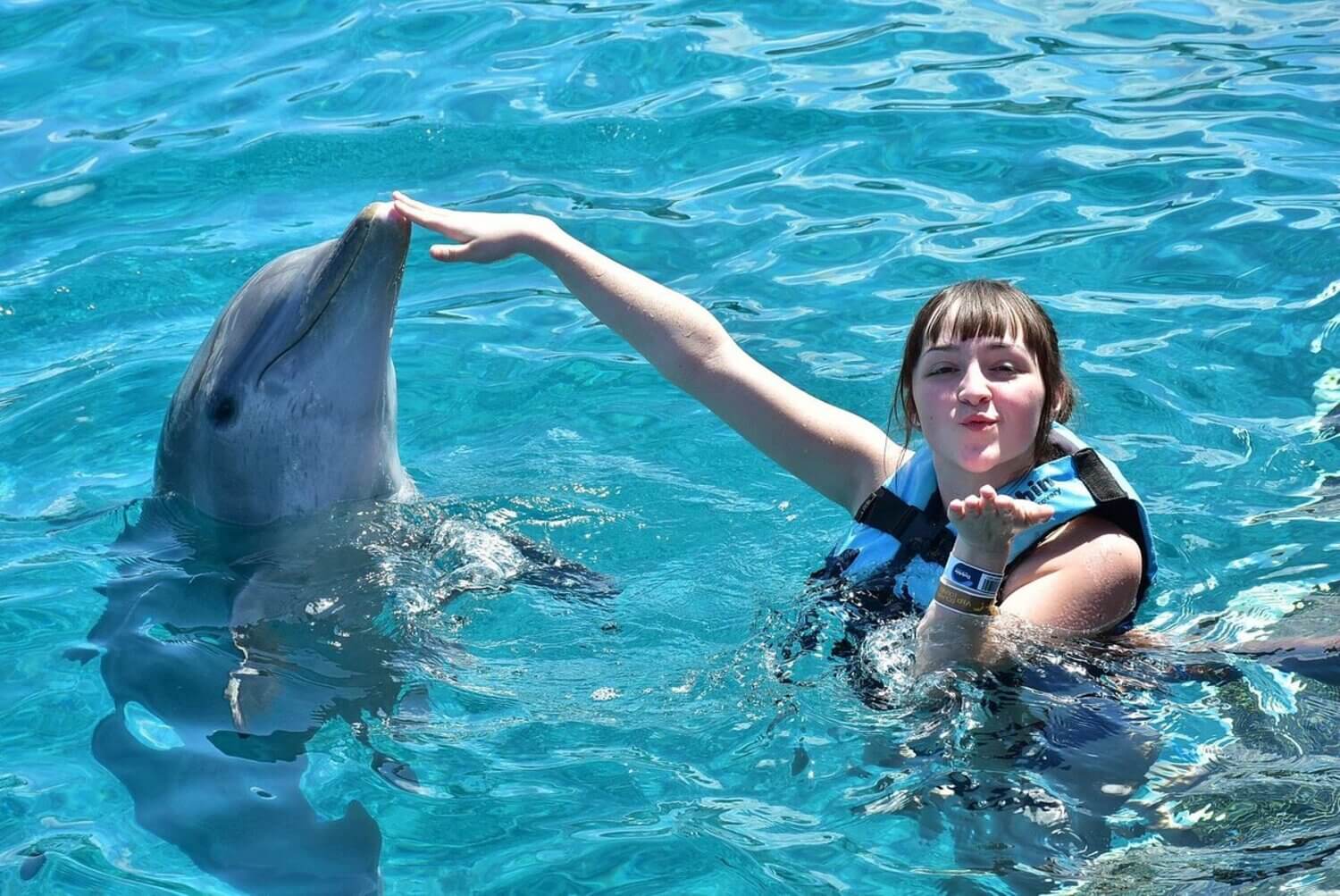 girl swimming with dolphins on Isla Mujeres